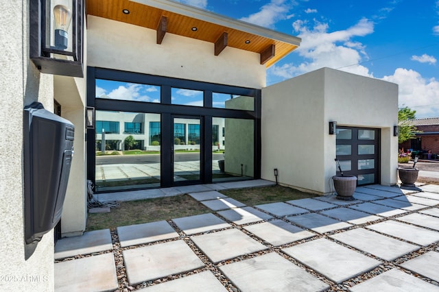 property entrance with stucco siding and a garage