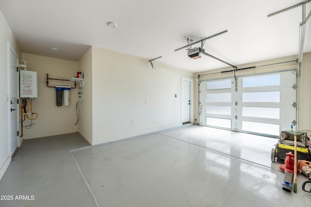 garage featuring baseboards, a garage door opener, and water heater