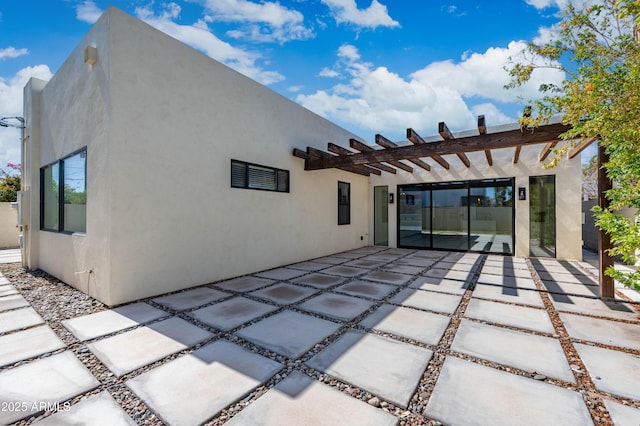 back of property with a patio, a pergola, and stucco siding