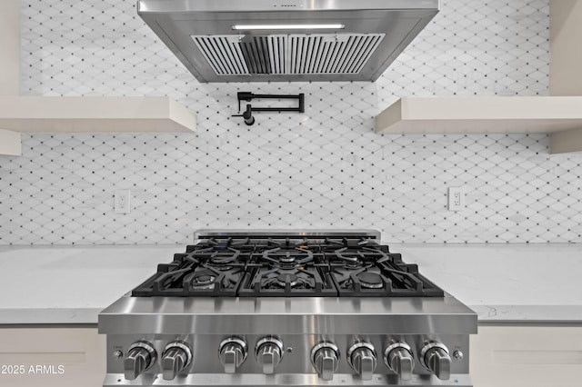 interior details featuring extractor fan, stainless steel gas stovetop, light stone countertops, and stove