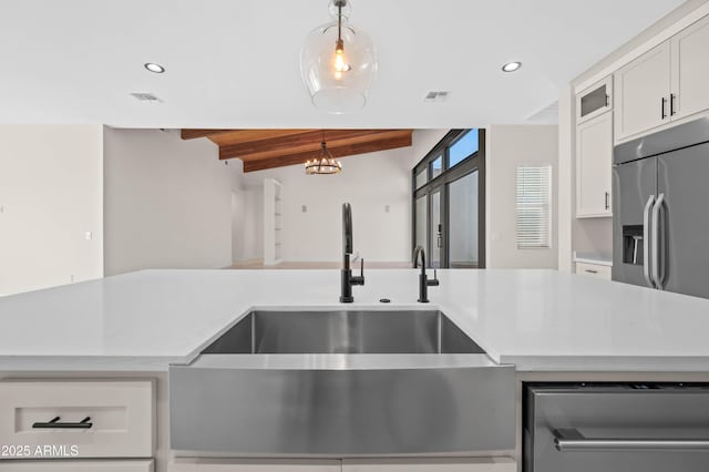 kitchen with visible vents, pendant lighting, built in refrigerator, wooden ceiling, and a sink