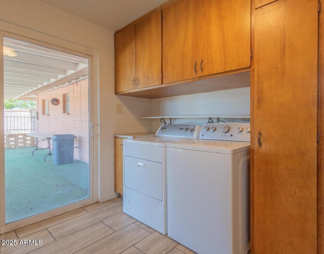 laundry room with washing machine and dryer and cabinets