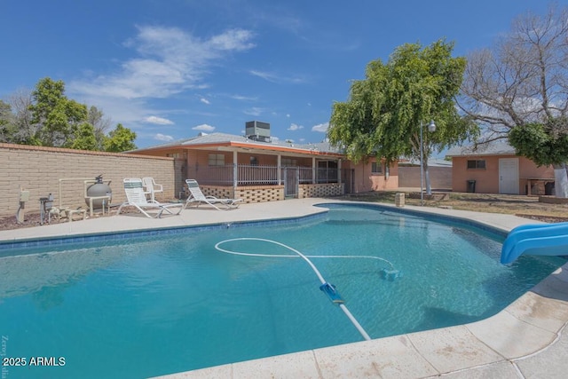 view of swimming pool with a water slide and a patio