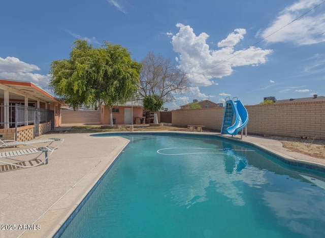 view of swimming pool with a patio area and a water slide