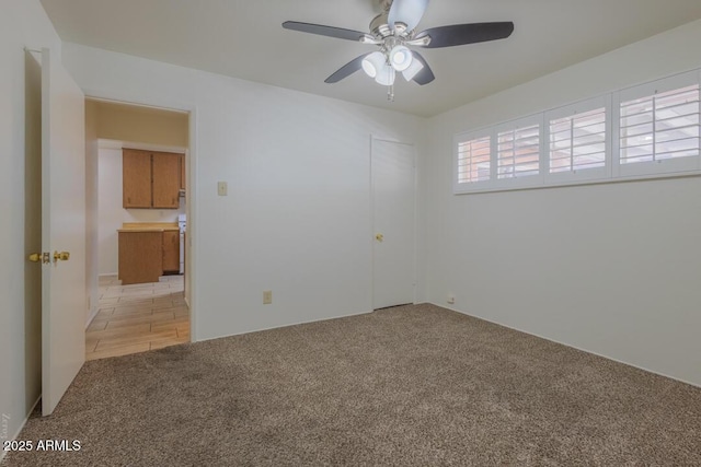 carpeted empty room featuring ceiling fan