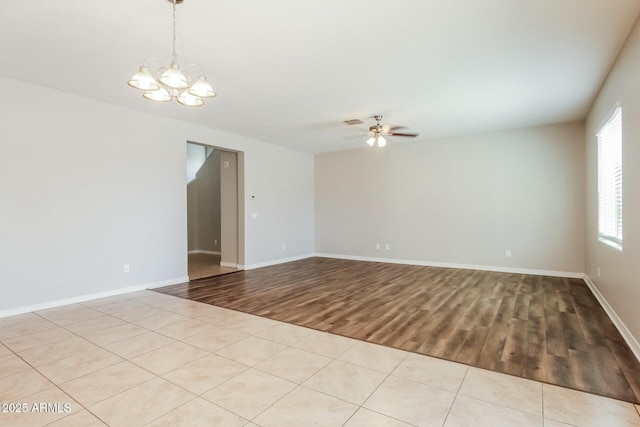 24479 W Mobile Ln, Buckeye, AZ 85326 - spare room featuring ceiling fan with notable chandelier, baseboards, wood finished floors, and visible vents