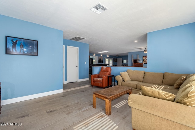 living room with hardwood / wood-style flooring and ceiling fan