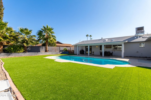 view of swimming pool featuring a patio and a lawn