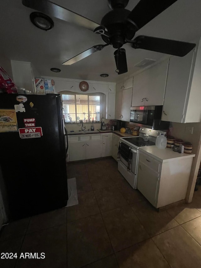 kitchen featuring white cabinetry, black fridge, dark tile patterned floors, and white range with electric cooktop