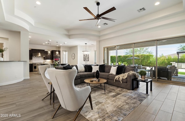 2821 E Cashman Dr, Phoenix, AZ 85050 - living room with a ceiling fan, light wood-type flooring, recessed lighting, and a raised ceiling