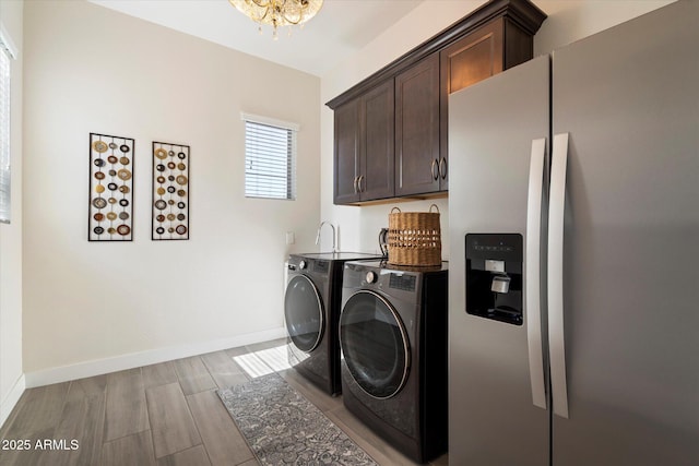 2821 E Cashman Dr, Phoenix, AZ 85050 - washroom featuring washing machine and clothes dryer, cabinet space, a chandelier, and baseboards