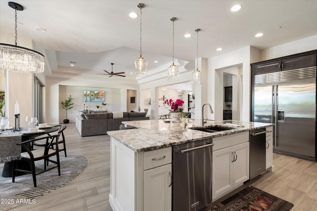 2821 E Cashman Dr, Phoenix, AZ 85050 - kitchen featuring appliances with stainless steel finishes, a sink, an island with sink, a raised ceiling, and recessed lighting