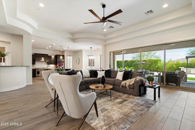 2821 E Cashman Dr, Phoenix, AZ 85050 - living area featuring light wood finished floors, ceiling fan, plenty of natural light, and recessed lighting