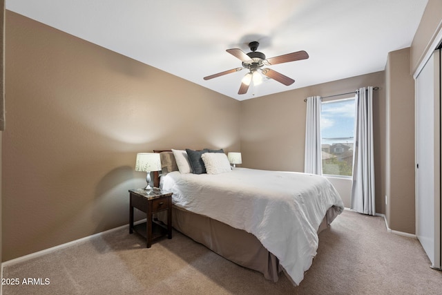 carpeted bedroom with ceiling fan and a closet