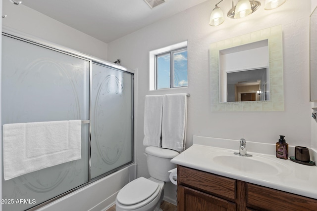 full bathroom featuring bath / shower combo with glass door, vanity, and toilet