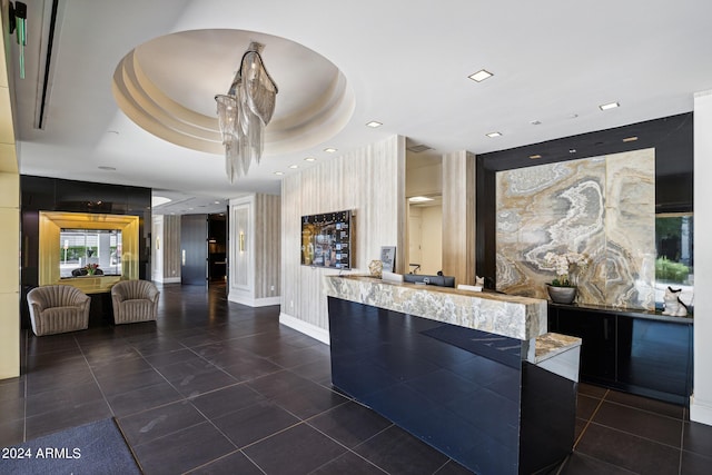 interior space with dark tile patterned flooring and a tray ceiling