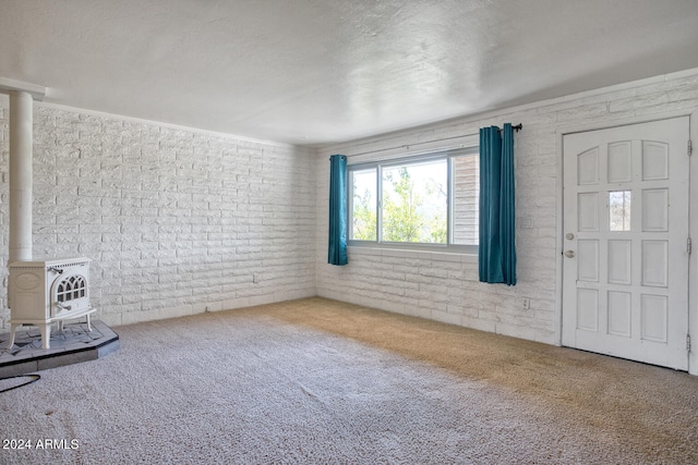 interior space with a wood stove and brick wall