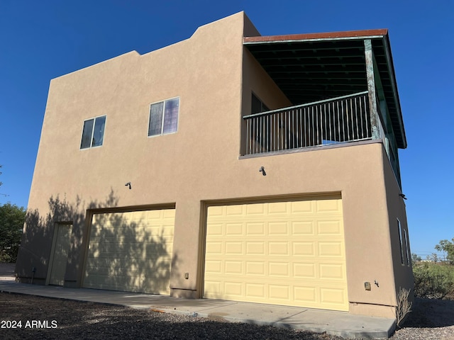 view of home's exterior with a garage and a balcony