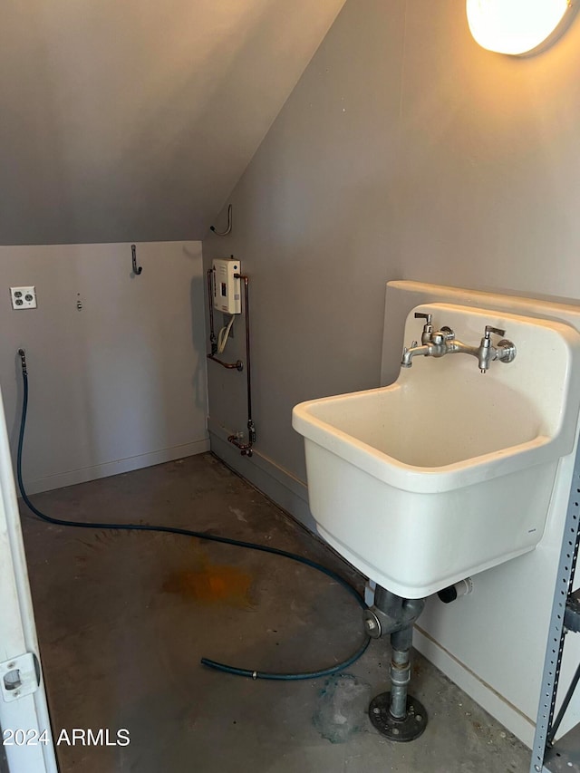 bathroom with concrete flooring and vaulted ceiling