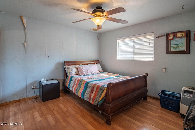 bedroom featuring a textured ceiling, ceiling fan, and light wood-type flooring