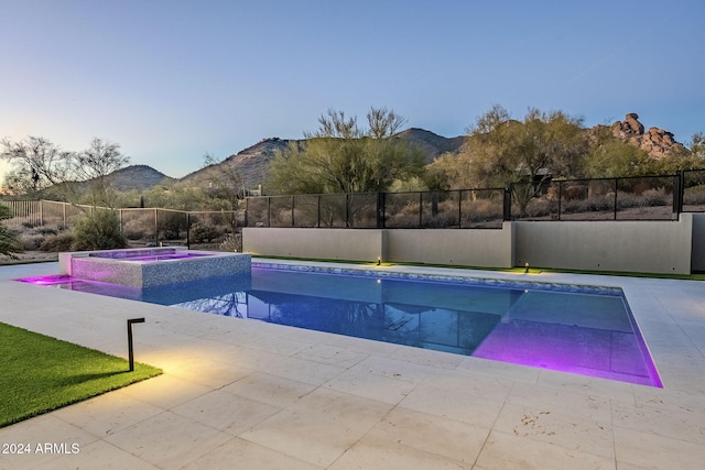 view of swimming pool with a mountain view, a patio area, and an in ground hot tub