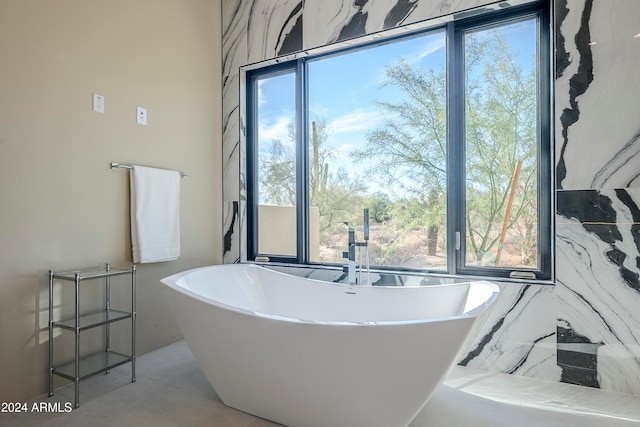 bathroom featuring a wealth of natural light and a tub