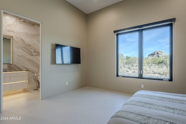 tiled bedroom with ensuite bathroom and tile walls