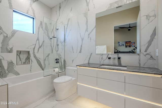 full bathroom featuring tiled shower / bath combo, ceiling fan, toilet, and vanity