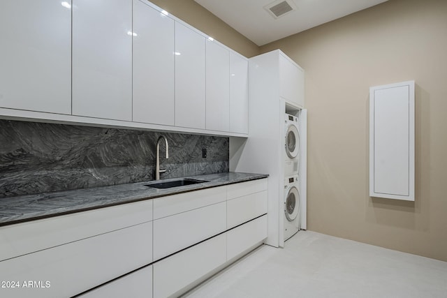 washroom with stacked washer and dryer and sink