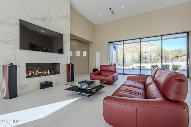 living room with lofted ceiling, a healthy amount of sunlight, and a premium fireplace