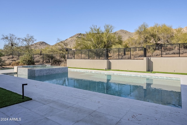 view of pool with a mountain view and an in ground hot tub