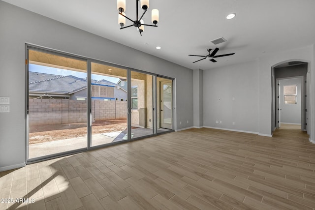 unfurnished living room with ceiling fan with notable chandelier