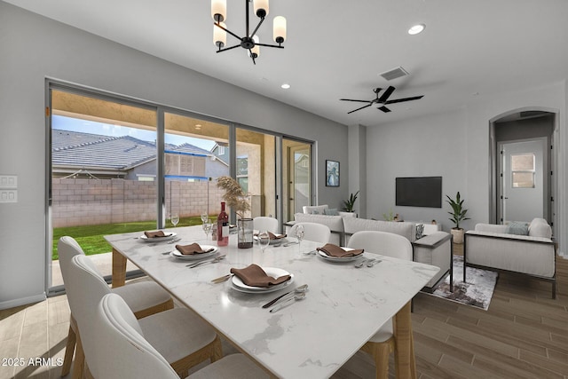 dining space featuring ceiling fan with notable chandelier