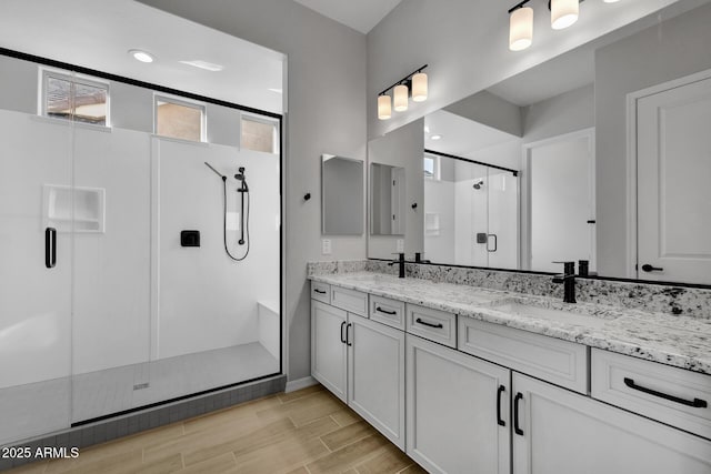 bathroom featuring vanity, a healthy amount of sunlight, and walk in shower