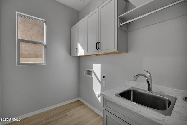 washroom with plenty of natural light, sink, cabinets, hookup for a washing machine, and electric dryer hookup