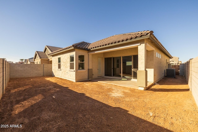 rear view of house with central AC unit and a patio area