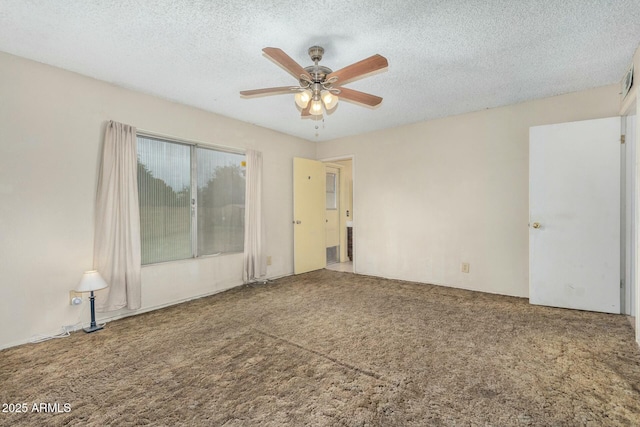 carpeted spare room with ceiling fan and a textured ceiling