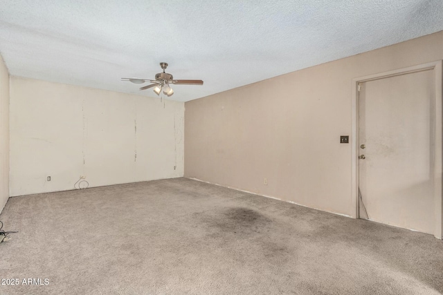 spare room featuring ceiling fan, carpet, and a textured ceiling