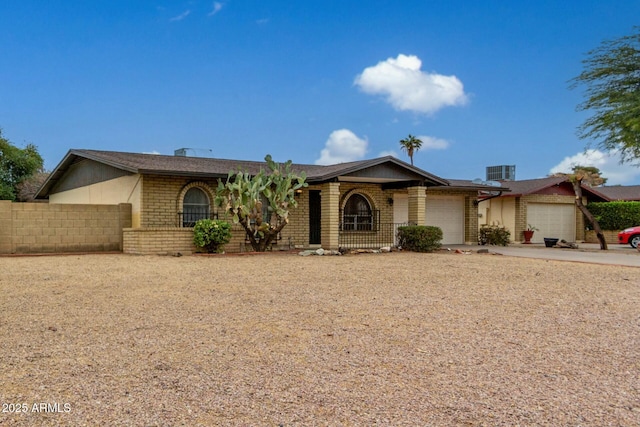 ranch-style home featuring a garage and cooling unit