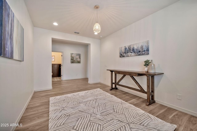 corridor featuring recessed lighting, visible vents, baseboards, and wood finished floors