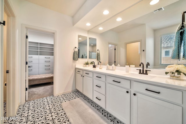 bathroom featuring double vanity, visible vents, a sink, and recessed lighting