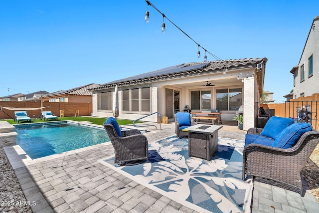 view of swimming pool with an outdoor living space with a fire pit, a patio area, ceiling fan, and a fenced backyard