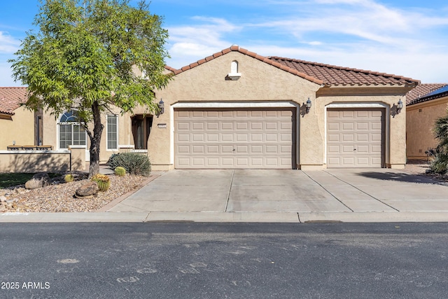 mediterranean / spanish house with stucco siding, a tiled roof, concrete driveway, and a garage