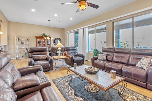 living area featuring recessed lighting, baseboards, ceiling fan with notable chandelier, and light wood finished floors