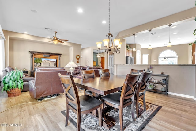 dining space with recessed lighting, visible vents, light wood-style flooring, and ceiling fan with notable chandelier