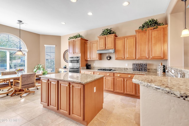 kitchen featuring light stone countertops, a kitchen island, recessed lighting, gas stovetop, and under cabinet range hood