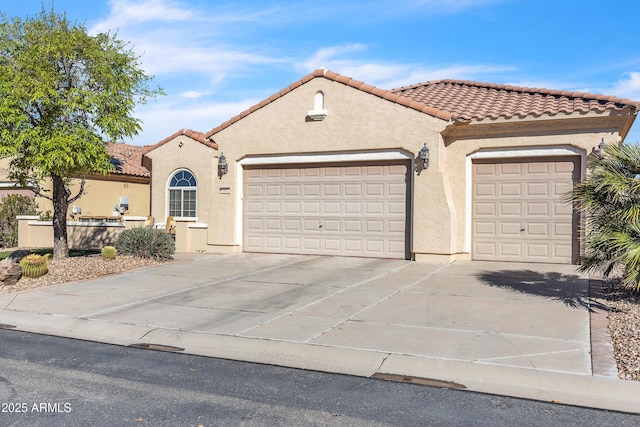 mediterranean / spanish house with stucco siding, an attached garage, a tile roof, and concrete driveway