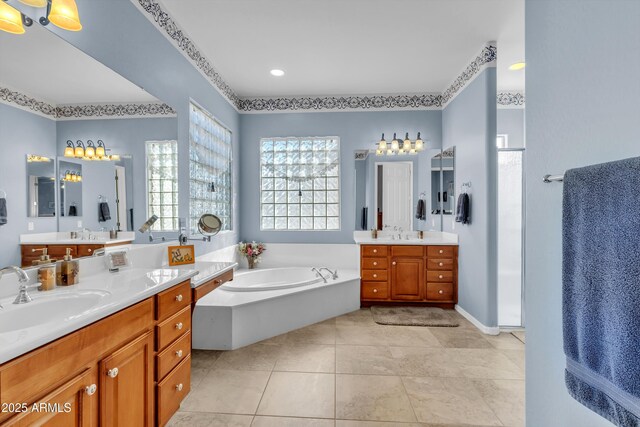 full bath with tile patterned floors, two vanities, a garden tub, and a sink