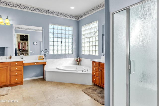 bathroom featuring tile patterned flooring, a stall shower, vanity, and a garden tub