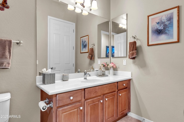 bathroom featuring baseboards, toilet, and vanity